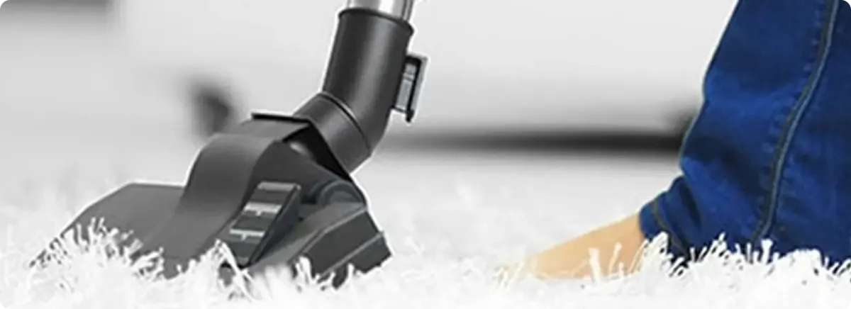 Close-up of a professional vacuuming a white carpet in Elizabeth.
